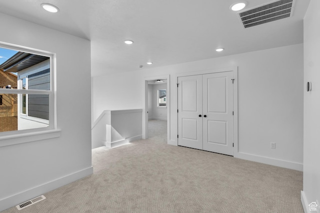 unfurnished room featuring visible vents, baseboards, and carpet
