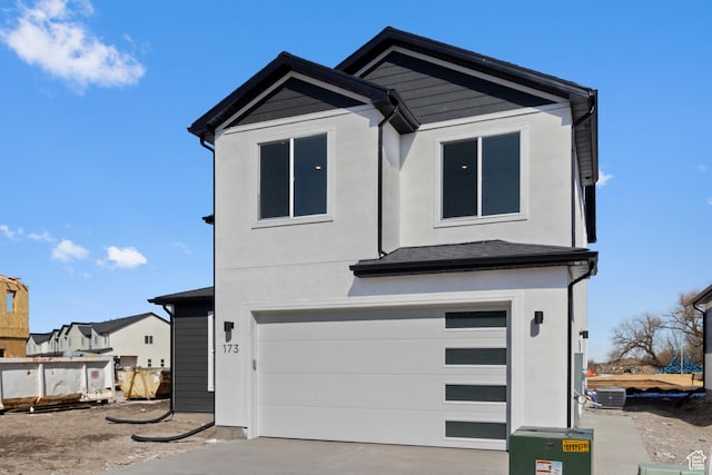 view of front of home featuring central AC unit, driveway, a garage, and stucco siding