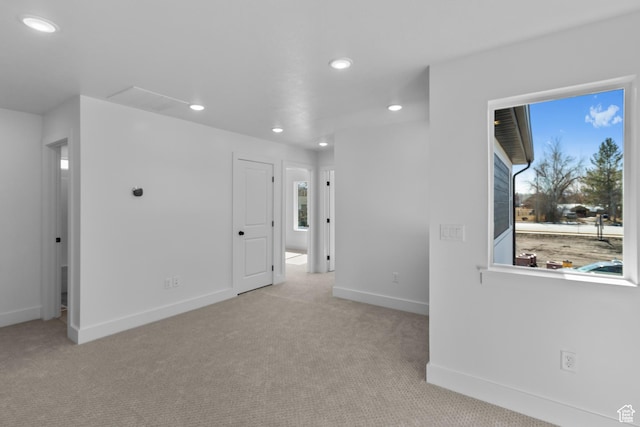 empty room with recessed lighting, light colored carpet, and baseboards