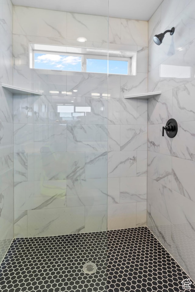 bathroom featuring a wealth of natural light and tiled shower