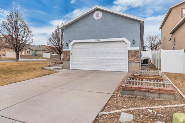 12972 S Cactus Berry Dr, Riverton, UT 84096 - view of side of home featuring concrete driveway, stone siding, an attached garage, fence, and stucco siding