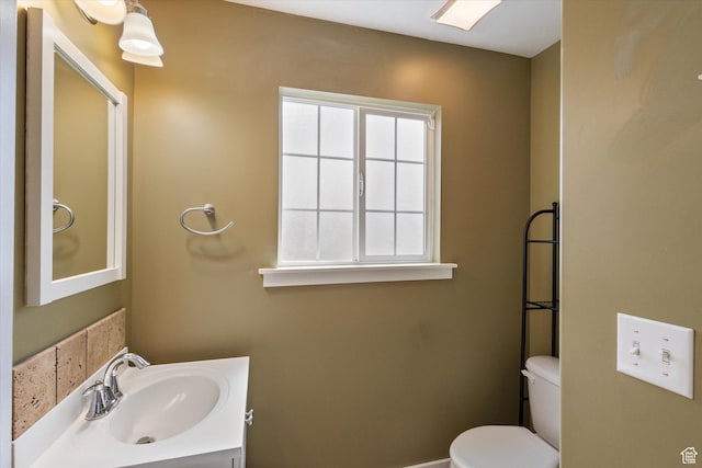 half bathroom with vanity and toilet