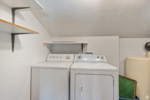 laundry area with laundry area, washer and clothes dryer, and a textured ceiling
