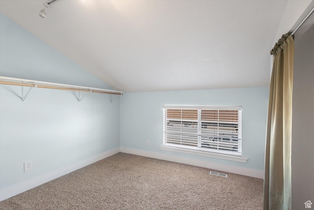 walk in closet with vaulted ceiling, carpet flooring, and visible vents