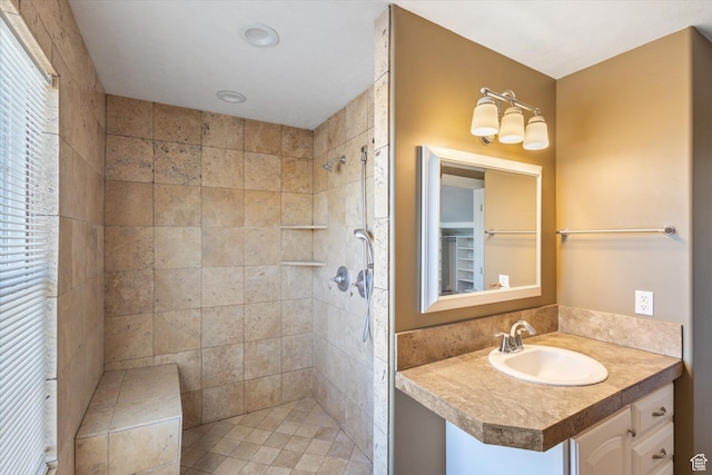 bathroom with a tile shower and vanity