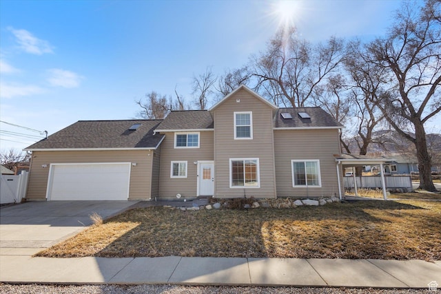 traditional-style house with an attached garage, a shingled roof, fence, and concrete driveway