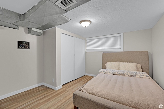 4868 S Ridgeline Dr, Washington Terrace, UT 84405 - bedroom featuring hardwood / wood-style flooring, a closet, and a textured ceiling