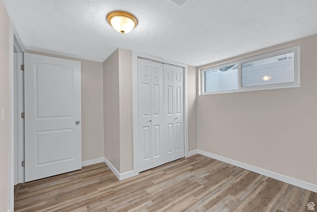 4868 S Ridgeline Dr, Washington Terrace, UT 84405 - unfurnished bedroom with light wood-type flooring, a closet, and a textured ceiling