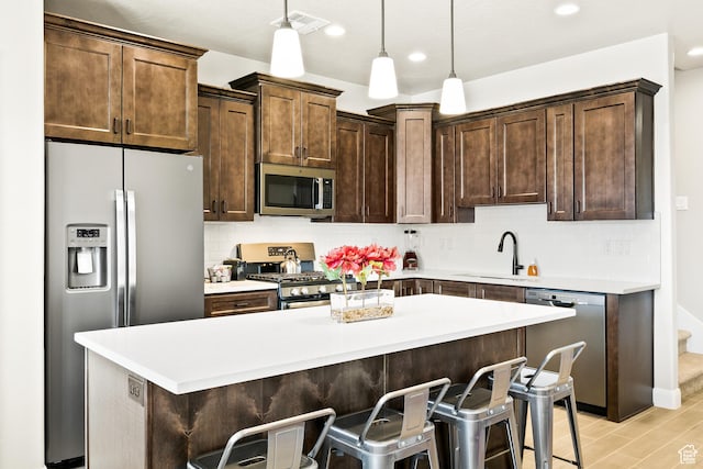 334 N 2020 W, Hurricane, UT 84737 - kitchen with sink, backsplash, pendant lighting, stainless steel appliances, and a breakfast bar area