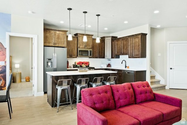 334 N 2020 W, Hurricane, UT 84737 - kitchen with a center island, stainless steel appliances, decorative light fixtures, a breakfast bar area, and decorative backsplash