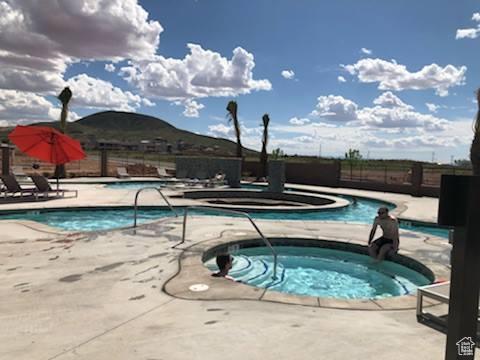 334 N 2020 W, Hurricane, UT 84737 - view of swimming pool featuring a hot tub, a patio, and a mountain view