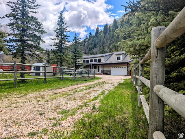 2326 Country Rd, Kamas, UT 84036 - view of front of home with driveway, fence, an attached garage, a view of trees, and a mountain view