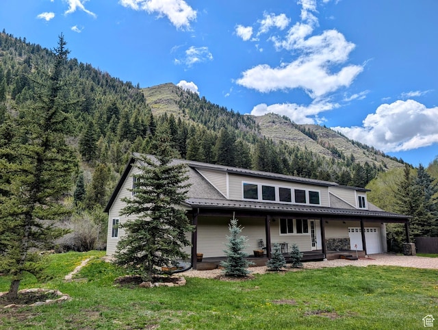 2326 Country Rd, Kamas, UT 84036 - view of front of house featuring a mountain view, a front lawn, decorative driveway, a wooded view, and a porch