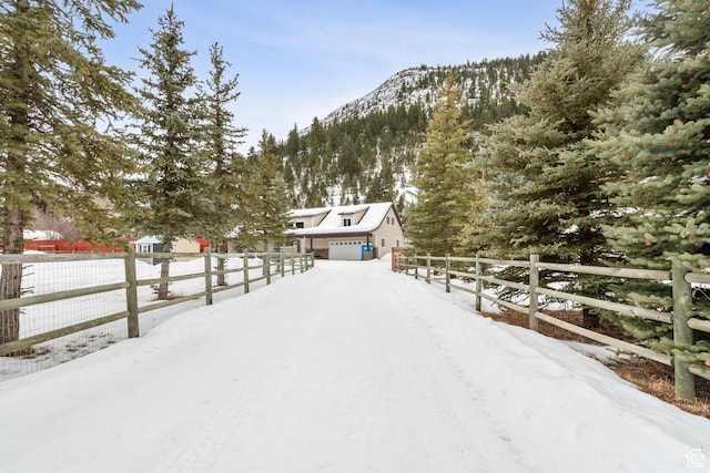 2326 Country Rd, Kamas, UT 84036 - snowy yard featuring a mountain view, fence, and a garage