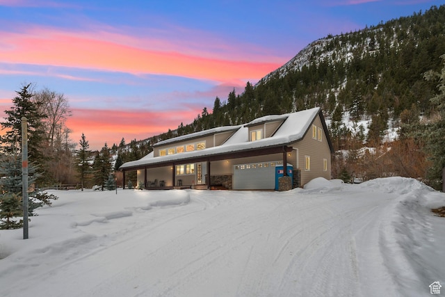 2326 Country Rd, Kamas, UT 84036 - view of front of property with a mountain view, stone siding, a porch, and a garage
