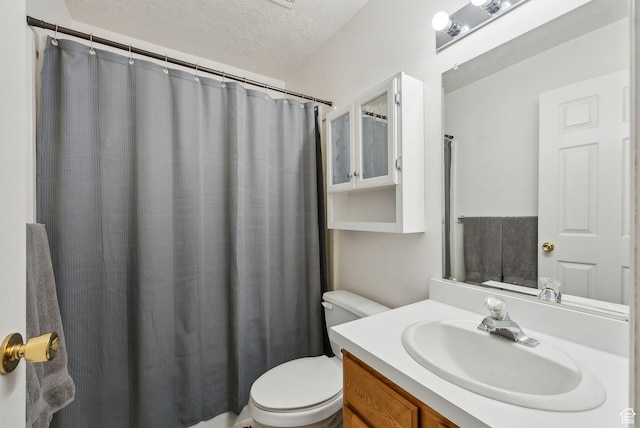 bathroom featuring a textured ceiling, toilet, and vanity