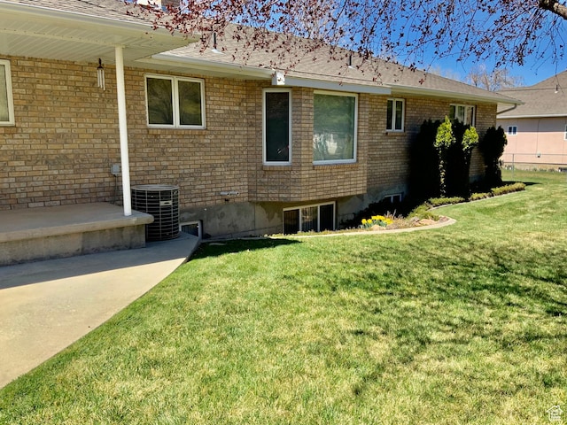 view of property exterior with central air condition unit and a lawn