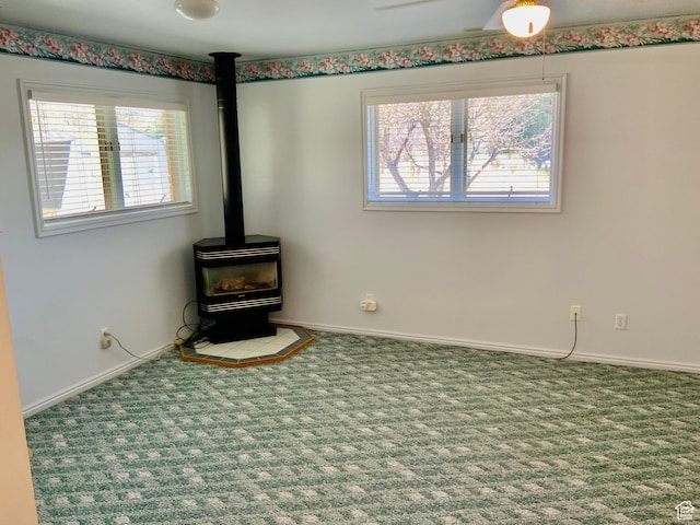 unfurnished living room featuring carpet and a wood stove