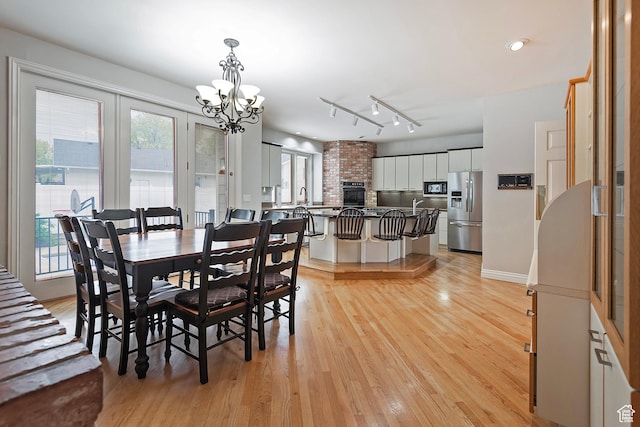 5845 Kerry Cir, Murray, UT 84107 - dining room with light hardwood / wood-style floors, track lighting, and a notable chandelier