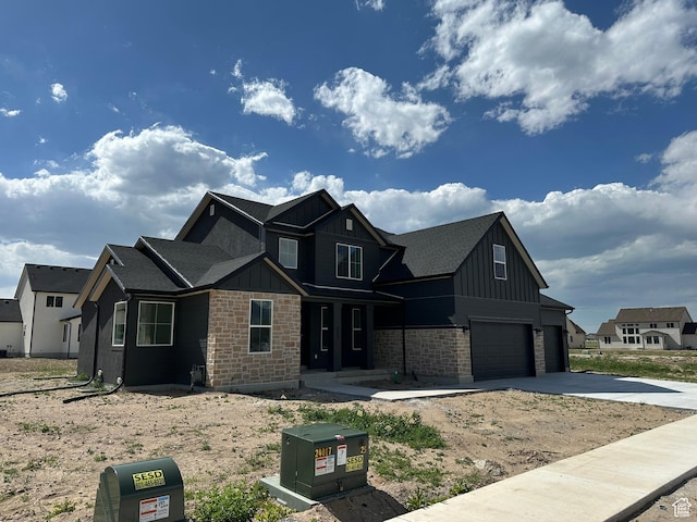 325 N 1040 E Unit 26, Salem, UT 84653 - view of front of property with board and batten siding, an attached garage, driveway, covered porch, and roof with shingles