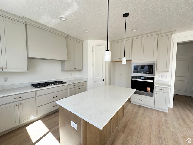 325 N 1040 E Unit 26, Salem, UT 84653 - kitchen with oven, light wood-style floors, premium range hood, gas cooktop, and a textured ceiling