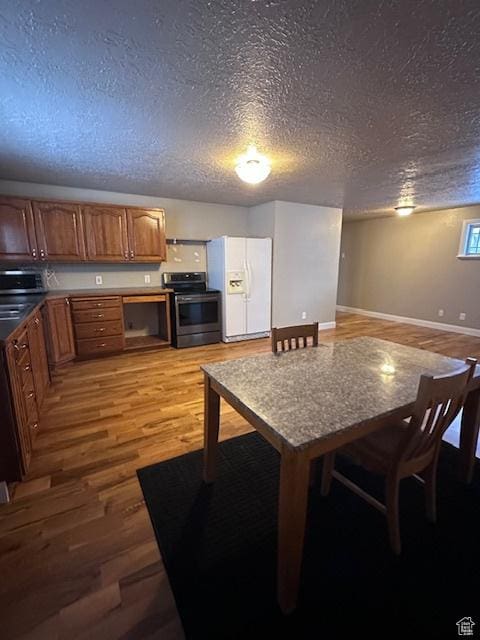 969 N 1200 W, Marriott Slaterville, UT 84404 - kitchen with stainless steel range with electric stovetop, white refrigerator with ice dispenser, a textured ceiling, and hardwood / wood-style floors