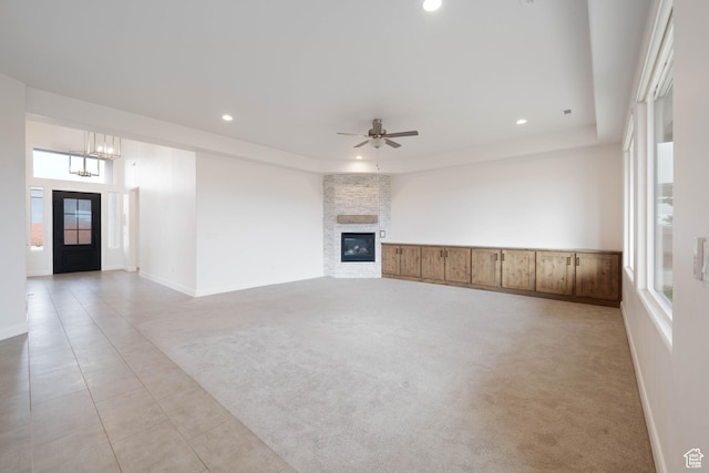 617 W 280 S, Ivins, UT 84738 - unfurnished living room featuring light carpet, ceiling fan with notable chandelier, a stone fireplace, and a raised ceiling
