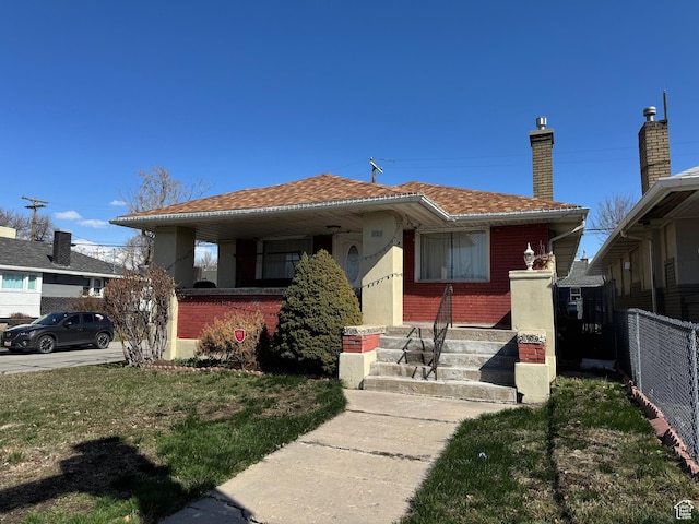 1135 S State St E, Salt Lake City, UT 84111 - bungalow-style house featuring fence, a chimney, a front lawn, and brick siding