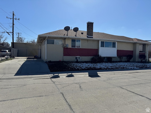 1135 S State St E, Salt Lake City, UT 84111 - view of front of house featuring brick siding, driveway, and a chimney