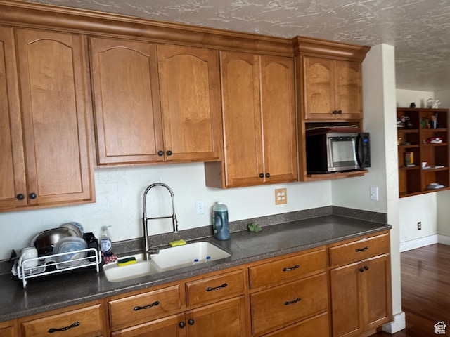 1135 S State St E, Salt Lake City, UT 84111 - kitchen with a sink, stainless steel microwave, brown cabinets, and dark wood finished floors