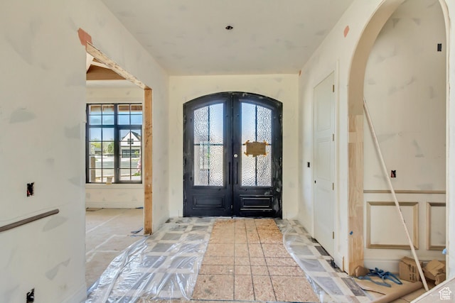 entryway featuring arched walkways and french doors