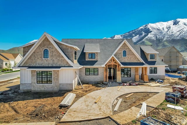 view of front of property with board and batten siding, a shingled roof, and a mountain view