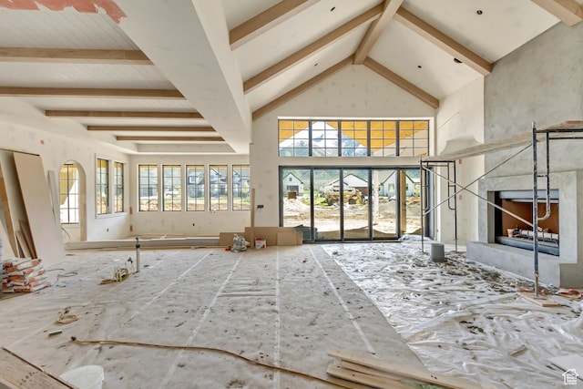 unfurnished living room with a wealth of natural light, a high end fireplace, and beam ceiling