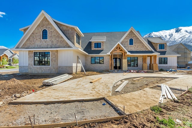 view of front of property featuring board and batten siding, a shingled roof, and a mountain view