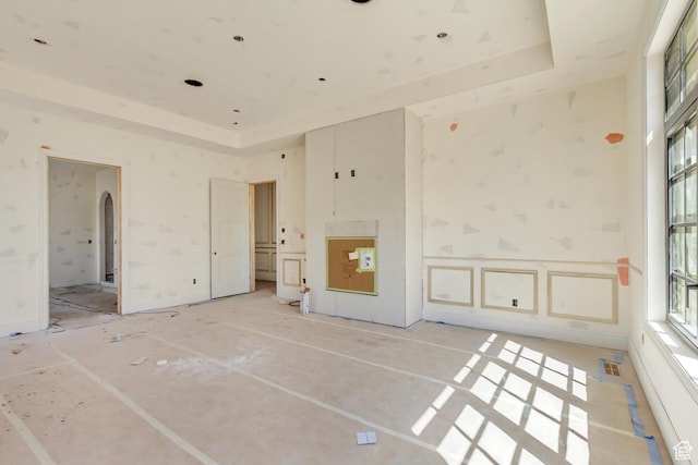 unfurnished bedroom with a tray ceiling and visible vents