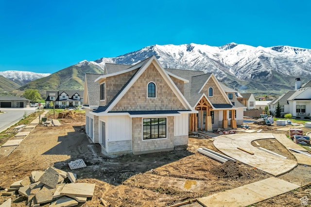 view of front of property with roof with shingles, a mountain view, and board and batten siding