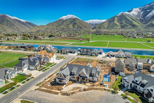 drone / aerial view with a water and mountain view and a residential view