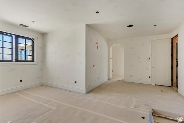 empty room with baseboards and arched walkways