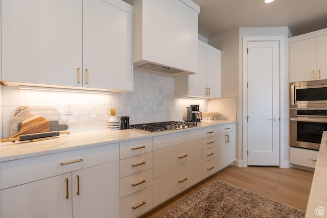 5398 S Aquamarine Ln, St George, UT 84790 - kitchen with appliances with stainless steel finishes, white cabinetry, light stone counters, and premium range hood