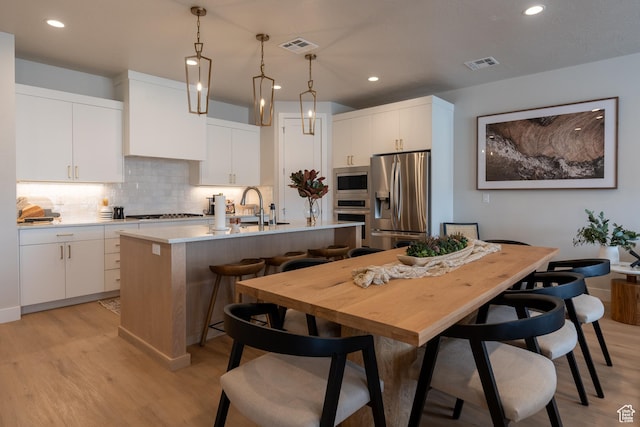 5398 S Aquamarine Ln, St George, UT 84790 - kitchen featuring a center island with sink, appliances with stainless steel finishes, and white cabinets