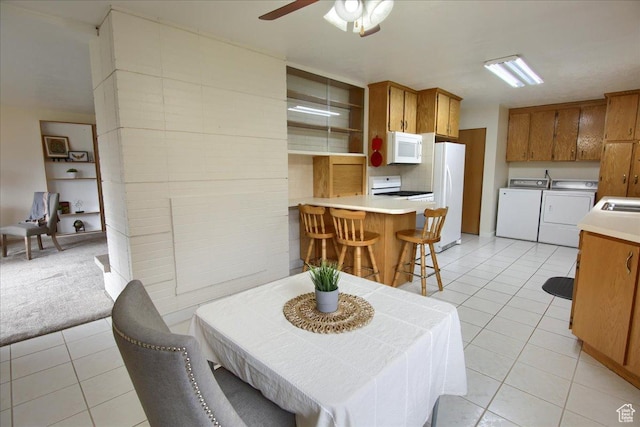 dining area with washing machine and dryer, light tile patterned flooring, and ceiling fan