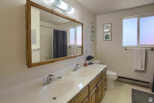 bathroom featuring a healthy amount of sunlight, baseboard heating, vanity, and toilet