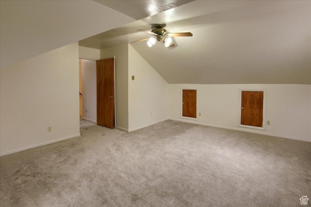 additional living space with ceiling fan, vaulted ceiling, and light colored carpet