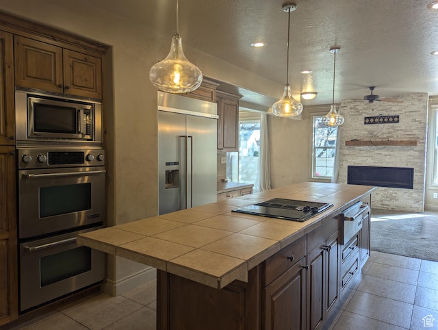 3006 E Somerset Dr, Spanish Fork, UT 84660 - kitchen featuring built in appliances, tile countertops, a center island, and a textured ceiling