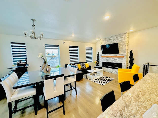 11587 S Prosperity Rd W, South Jordan, UT 84009 - dining room with light wood-type flooring, a notable chandelier, and a stone fireplace