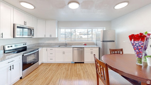 1125 N Trinnaman Ln, Lehi, UT 84043 - kitchen with sink, stainless steel appliances, white cabinetry, and light stone countertops