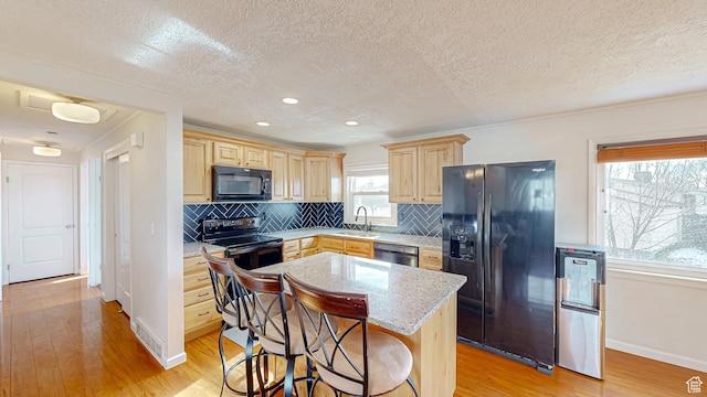 1125 N Trinnaman Ln, Lehi, UT 84043 - kitchen with light hardwood / wood-style flooring, black appliances, backsplash, a kitchen island, and sink