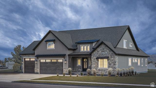 view of front of home with roof with shingles, concrete driveway, a front yard, a garage, and stone siding