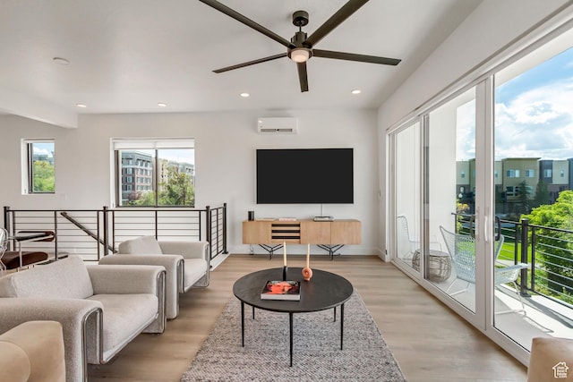 living room with a ceiling fan, recessed lighting, light wood-style flooring, and a wall unit AC