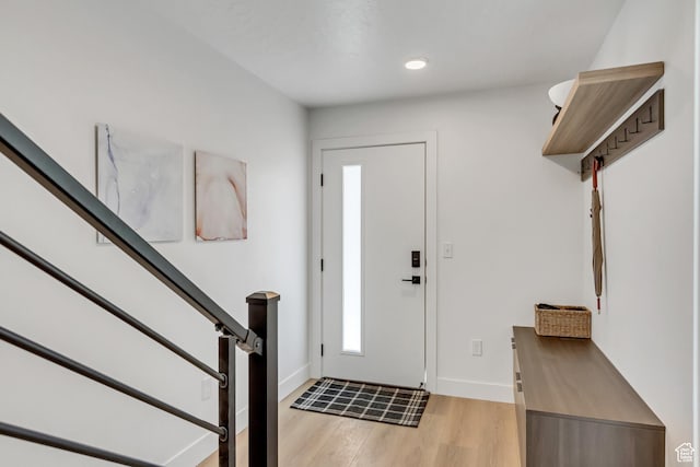 foyer featuring baseboards, stairs, light wood-style floors, and recessed lighting